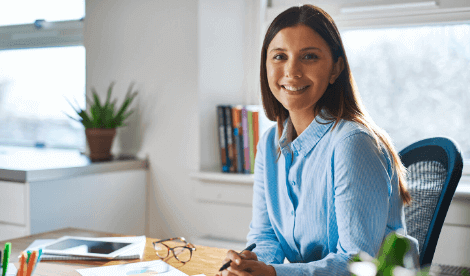 A smiling woman looking to camera in home office