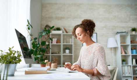 A woman working from her home office in front of a computer - signifying the job retention scheme