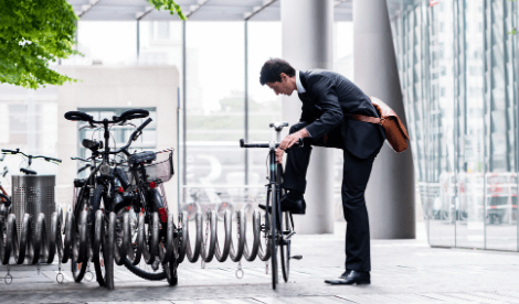 Corporate man riding bike