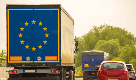 A lorry with the EU logo on the back driving amongst other traffic on a motorway