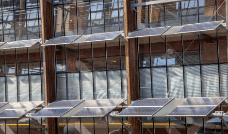 Modern building with solar panels mounted on the side acting as shade for inside the building