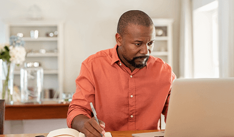 A man working from home in front of laptop to manage a charity crisis