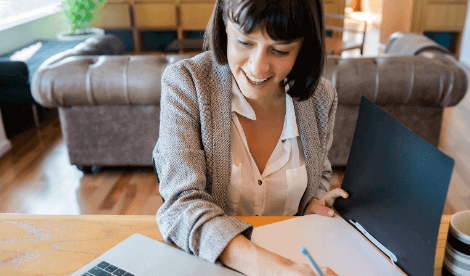 A happy woman working from home with paperwork