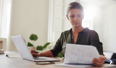 Business woman working from home looking at state aid paperwork