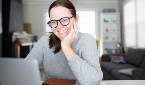 Lady smiling at Laptop screen