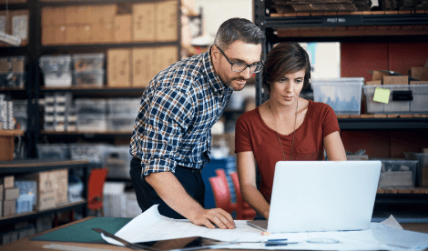 business partners working on computer in warehouse environment