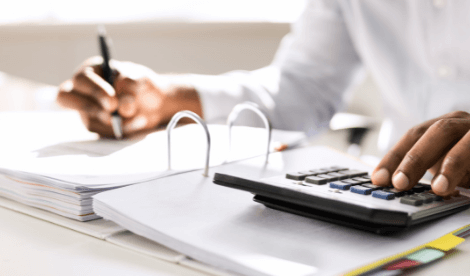 Person using calculator and pen at desk