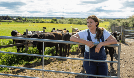 Farmer standing in rural field with cows | Kreston Reeves